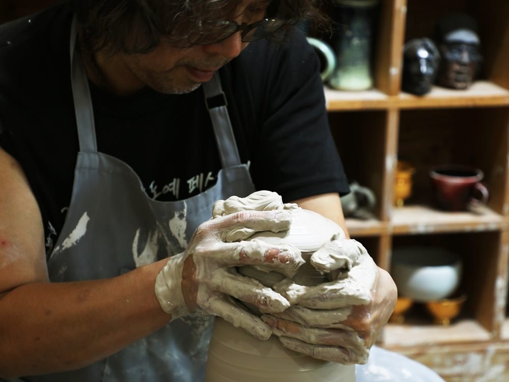 Les mains de Shin Hyun Moon montent une colonne de terre sur le tour